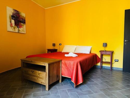 a yellow room with a bed with a red blanket at Casa Gio in Lesa