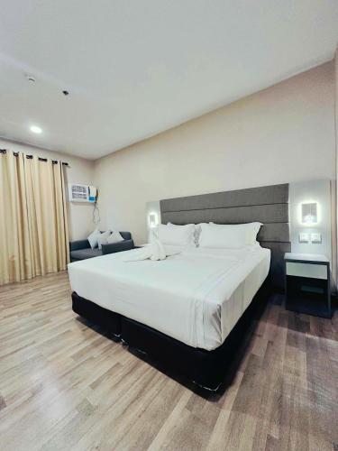 a bedroom with a large white bed in a room at Staycity Serviced Apartment in Cebu City