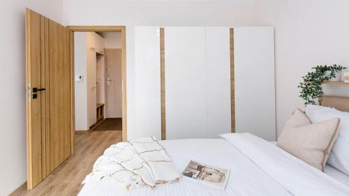 a bedroom with a white bed with a mirror at Baltic Line - Sobieszewski Raj in Gdańsk