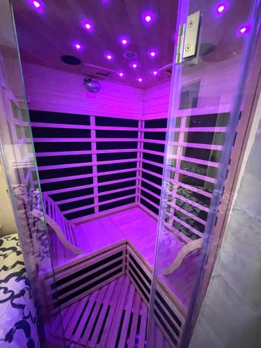 une pièce vide avec des lumières violettes au plafond dans l'établissement La détente avec jardin, sauna et parking privé au coeur de Stella-Plage, à Stella-Plage