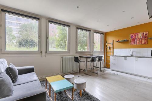 un salon avec un canapé et une cuisine dans l'établissement Beaugrenelle Tour Eiffel I Cosy Apartment 4P, à Paris