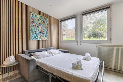 une chambre avec un lit et deux fenêtres dans l'établissement Beaugrenelle Tour Eiffel I Cosy Apartment 4P, à Paris