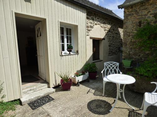 un patio avec une table et des chaises et un bâtiment dans l'établissement Château de BEL AIR, à Aucaleuc