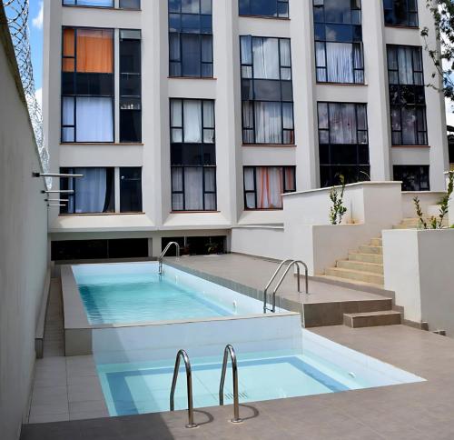 a swimming pool in front of a building at Lavish Apartment with Swimming Pool Ongata Rongai in Nairobi