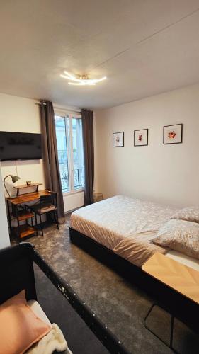 une chambre avec un lit et un bureau dans l'établissement Charmant T2 Rénové, Calme & Lumineux, Paris 17e, à Paris