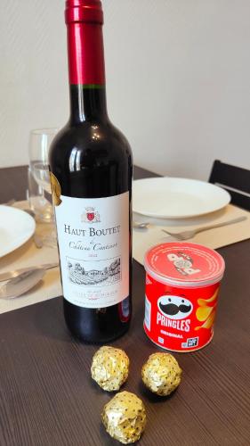 une bouteille de vin à côté d'une boîte de crackers dans l'établissement Charmant T2 Rénové, Calme & Lumineux, Paris 17e, à Paris