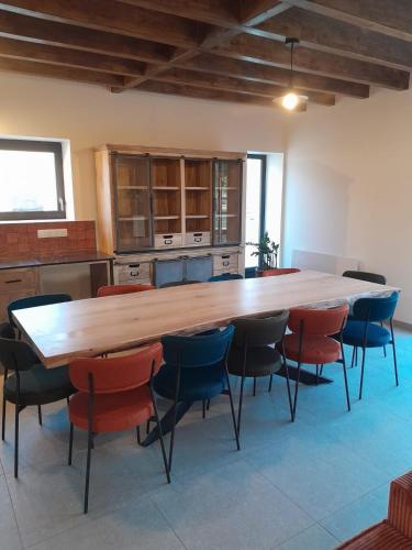 une grande cuisine avec une grande table et des chaises en bois dans l'établissement La gite des 1000 plantes, à Courcelles-de-Touraine