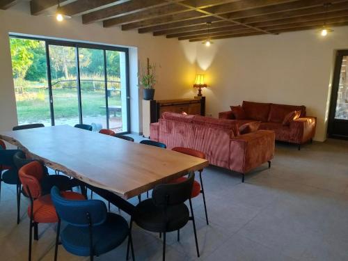 un salon avec une table, des chaises et un canapé dans l'établissement La gite des 1000 plantes, à Courcelles-de-Touraine