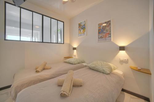 deux lits côte à côte dans une chambre dans l'établissement Le Cali - Front de mer - Palm Beach - VCA, à Cannes