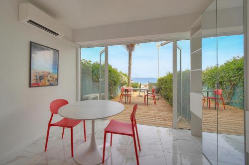 une salle à manger avec une table et des chaises sur un balcon dans l'établissement Le Cali - Front de mer - Palm Beach - VCA, à Cannes