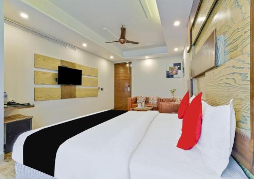 a bedroom with a large white bed with red pillows at Hotel N Maharani in New Delhi