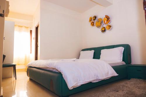 a bedroom with a bed with a green head board at Hotel Dilli-Phu in Bomdila