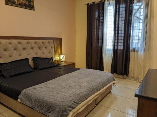 une chambre avec un grand lit et une fenêtre dans l'établissement Mrityunjay Yogpeeth, à Jāmb