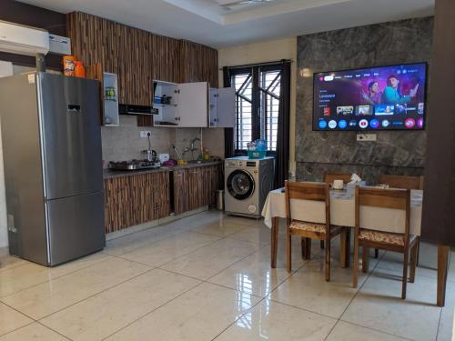 Il comprend une cuisine équipée d'un réfrigérateur et d'une table avec des chaises. dans l'établissement Mrityunjay Yogpeeth, à Jāmb