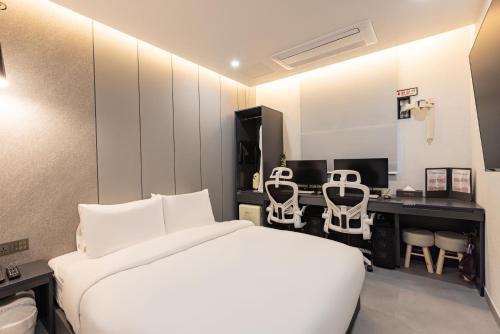 a bedroom with a bed and a desk with chairs at Giverny Hotel in Gyeongju