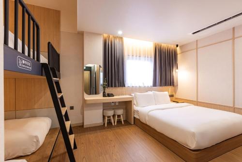 a hotel room with two beds and a desk at Giverny Hotel in Gyeongju