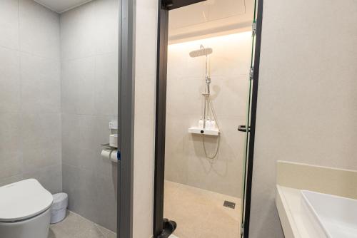 a bathroom with a shower with a toilet and a sink at Giverny Hotel in Gyeongju