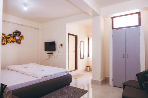 a bedroom with a bed and a tv in it at Hotel Dilli-Phu in Bomdila
