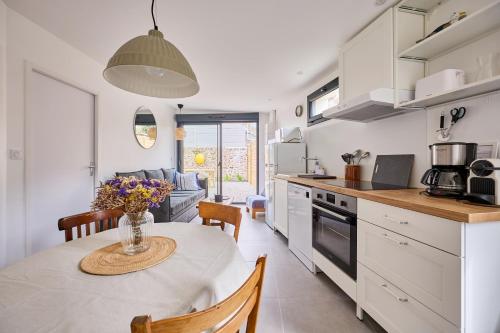 une cuisine avec une table avec un vase de fleurs dessus dans l'établissement Vicky - Proche du port de Carteret, à Barneville-Carteret
