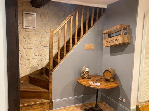 a room with a wooden staircase and a table at Les Gîtes de Monthermé Le Duplex avec vue sur la Meuse in Monthermé