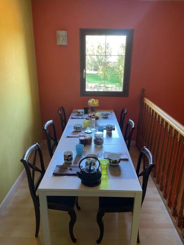 - une table avec de la vaisselle dans une pièce dans l'établissement Echappée belle verdoyante 20 min du Puy, à Mauléon