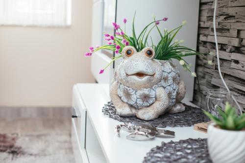 a frog statue sitting on a counter with flowers at Holiday Home Gracia in Luka
