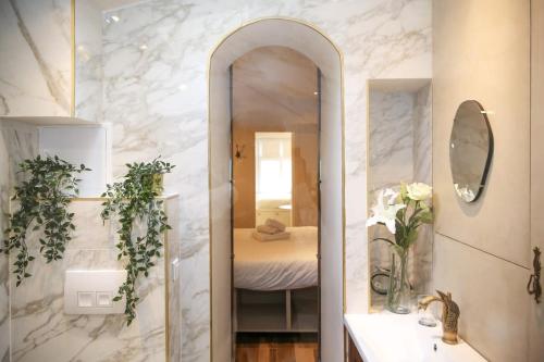 - une salle de bains avec un miroir et un lit dans une chambre dans l'établissement Appartement cosy Montmartre - Paris 18 - 4P, à Paris