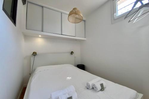 - une chambre blanche avec un lit et deux serviettes dans l'établissement The cozy! Air-conditioned city centre with one bedroom, à Montpellier