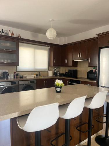 a kitchen with a table and two white chairs at Lazuli Zen Villa with Private Pool in Pyla