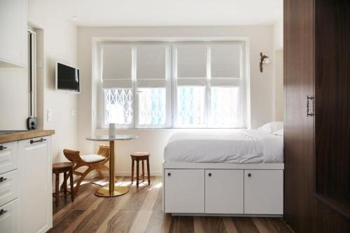 une chambre avec un lit avec une fenêtre et une table dans l'établissement Appartement cosy Montmartre - Paris 18 - 4P, à Paris