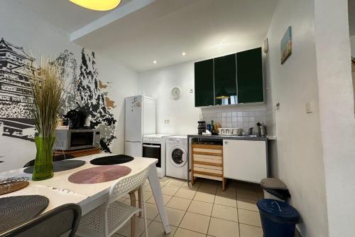 une cuisine avec des appareils blancs et une table avec des chaises dans l'établissement The Triplex- 3 bedrooms in the escutcheon!, à Montpellier