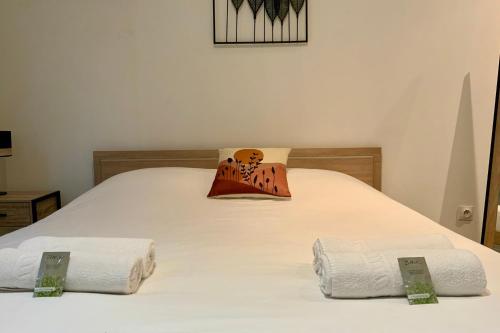- un lit avec 2 serviettes blanches dans l'établissement Le Coquet - Studio with air conditioning!, à Montpellier