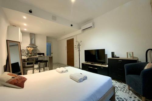 - une chambre avec un lit blanc et un salon dans l'établissement Le Coquet - Studio with air conditioning!, à Montpellier