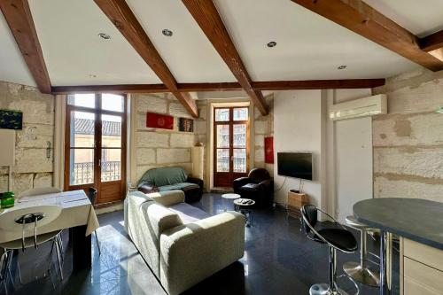 un salon avec un canapé et une télévision dans l'établissement The Duplex- Air-conditioned 3 bedrooms in the center of Montpellier!, à Montpellier