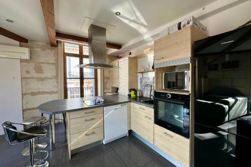 - une cuisine avec un comptoir et une cuisinière four supérieur dans l'établissement The Duplex- Air-conditioned 3 bedrooms in the center of Montpellier!, à Montpellier