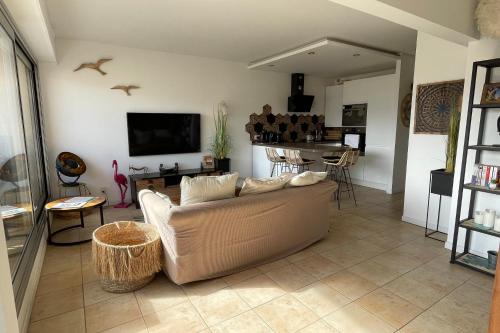 un salon avec un canapé et une table dans l'établissement Le Port Camargue - 2 bedrooms air conditioning terrace and swimming pool!, au Grau-du-Roi