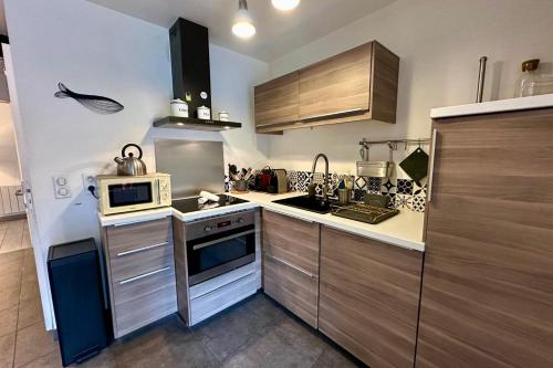 une cuisine avec un évier et une cuisinière four supérieur dans l'établissement Le Jardinet - With office in the city center!, à Castelnau-le-Lez