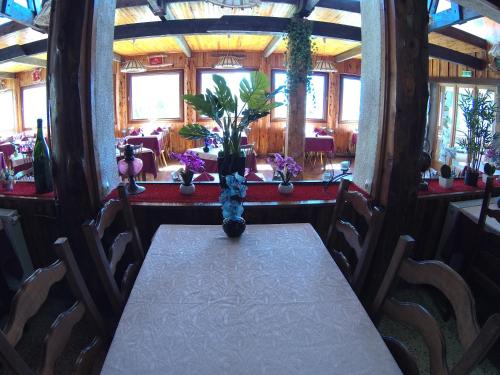 a dining room with a table and chairs with flowers at Boustigue Hotel in Corps