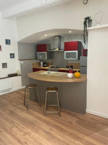 une cuisine avec un îlot et deux tabourets de bar dans l'établissement Le Montpelliérain - Studio dans l’écusson !, à Montpellier