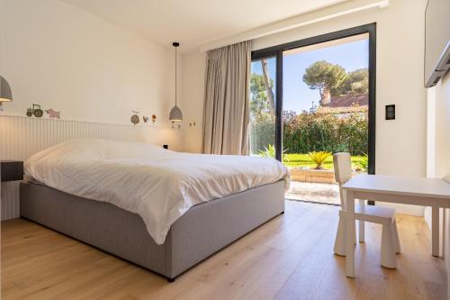 une chambre avec un lit et une grande fenêtre dans l'établissement Villa Koya, à Antibes