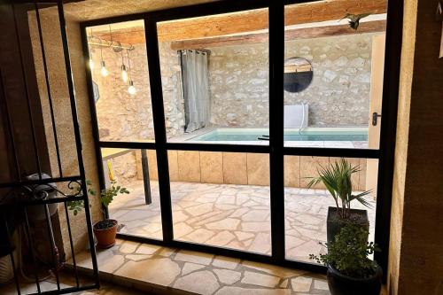 - une vue sur la piscine depuis une porte coulissante en verre dans l'établissement L'Uzétienne- Large residence with pond and patio!, à Pouzilhac