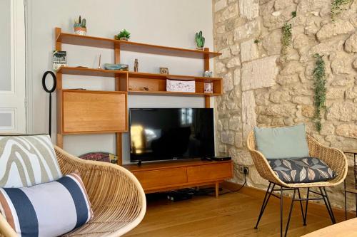 salon z telewizorem i 2 krzesłami w obiekcie Le Coeur de Ville - Charmant pour 2 personnes ! w Montpellier