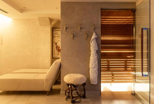 a bedroom with a bed and a stool in a room at Auberge de La Maison in Courmayeur