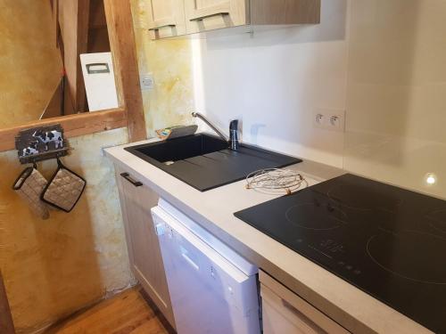 une petite cuisine avec un évier et une cuisinière dans l'établissement Vacances en pays cathare réservable du samedi au samedi les mois de Juillet et Aout, à Joucou