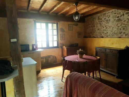 une chambre avec une table et une cuisine avec une fenêtre dans l'établissement Vacances en pays cathare réservable du samedi au samedi les mois de Juillet et Aout, à Joucou