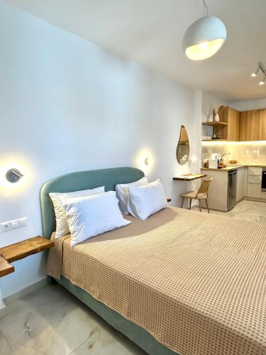 a bedroom with a large bed and a kitchen at Luaz Naxian living in Naxos Chora