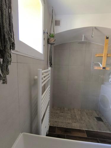 Elle comprend une petite salle de bains pourvue d'une baignoire et d'une fenêtre. dans l'établissement Appartement Les Issambres 4 pers, à Roquebrune-sur Argens