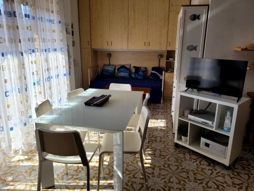 a living room with a table and a tv and a bed at Sea la vie - Holiday house in Nettuno