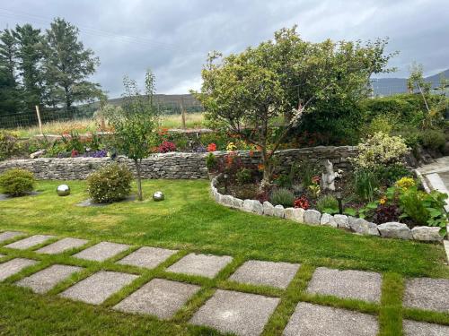 a garden with a stone wall and some plants at Laburnum B&B in Kenmare