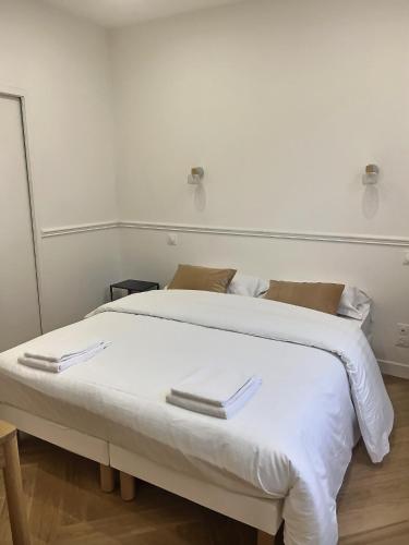 d'un lit blanc avec deux serviettes au dessus dans l'établissement Château Versailles, logement Neuf, à Versailles